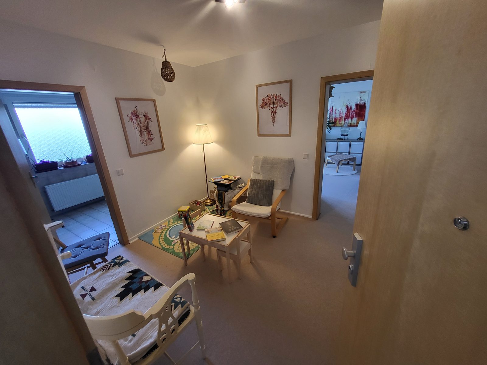 Wartebereich mit Spielteppich und Sessel